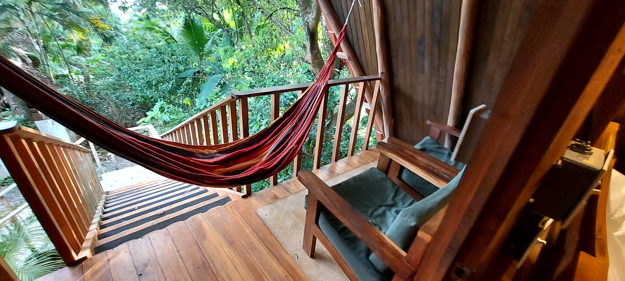 Treehouse Chilo covered porch with hammock and tropical canopy views at Hacienda Nosara